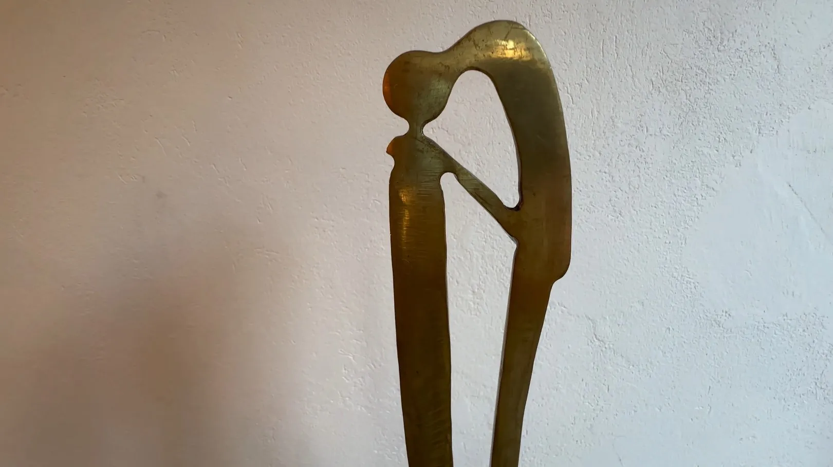 Escultura antigua con forma estilizada y base decorativa.