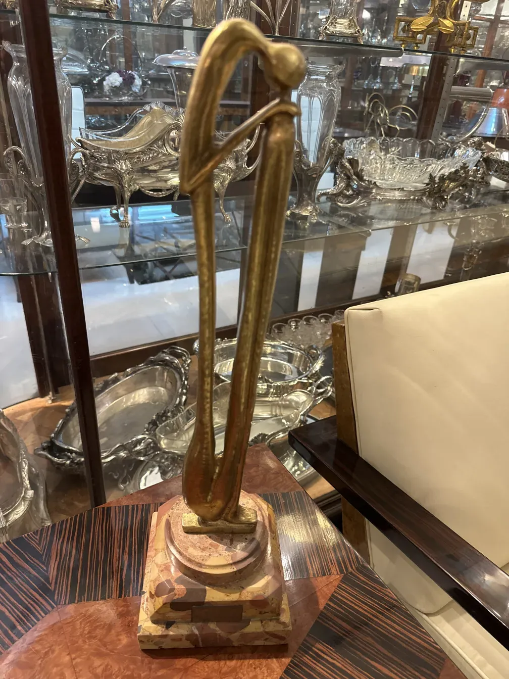Escultura antiga com forma elegante e base decorativa.