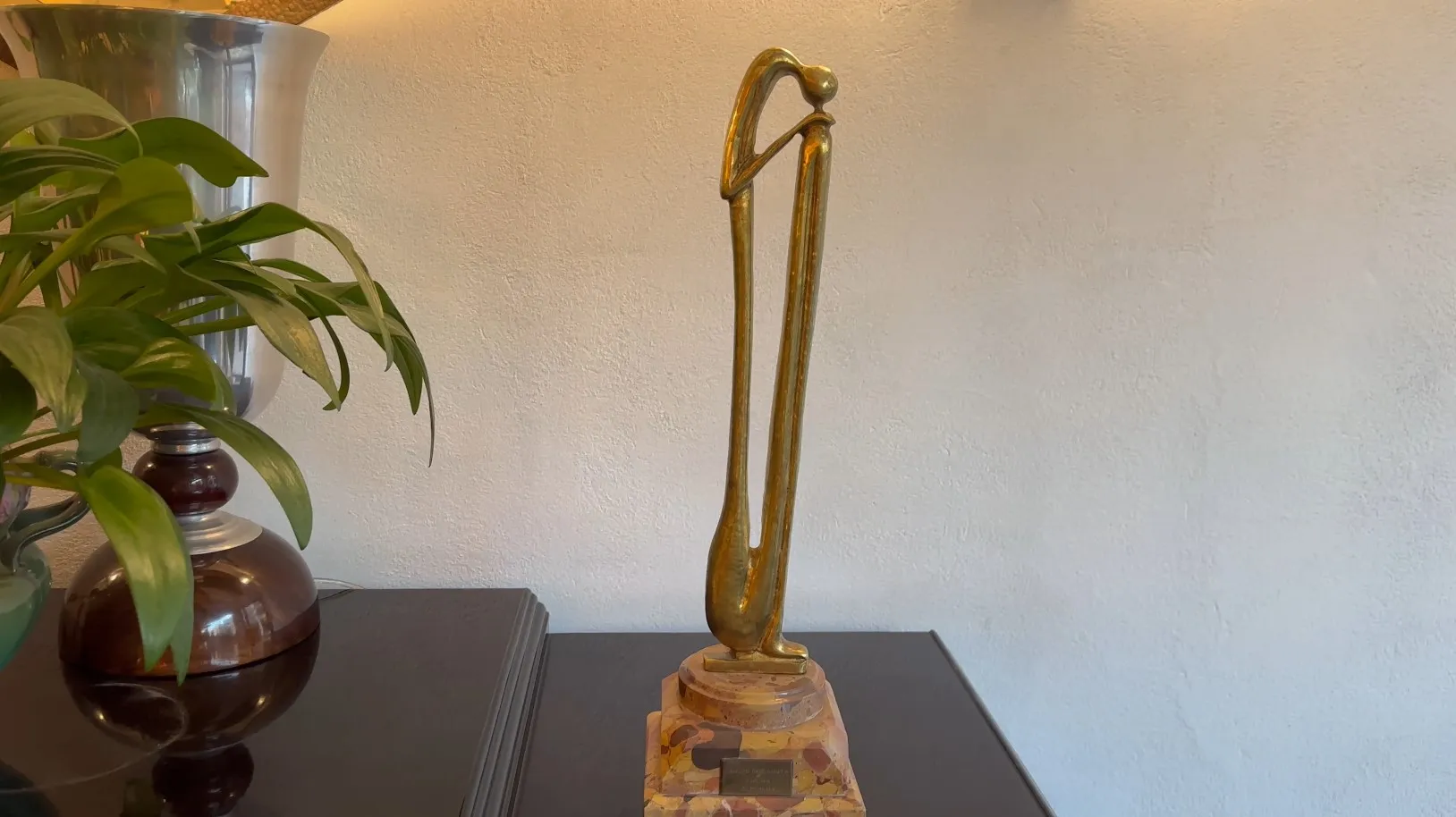 Escultura antigua con forma estilizada y base decorativa.
