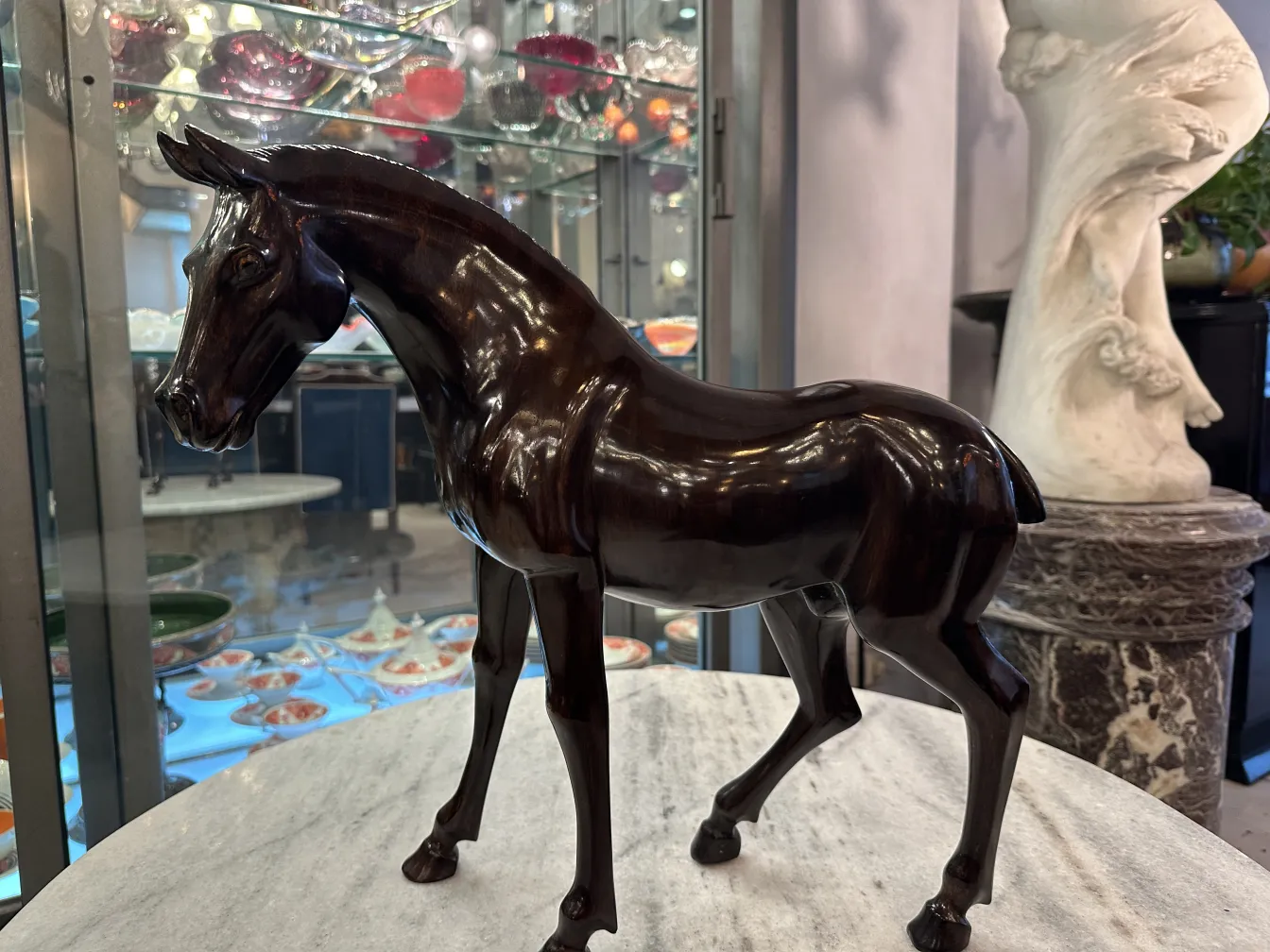 Escultura antigua de un caballo con acabado brillante.
