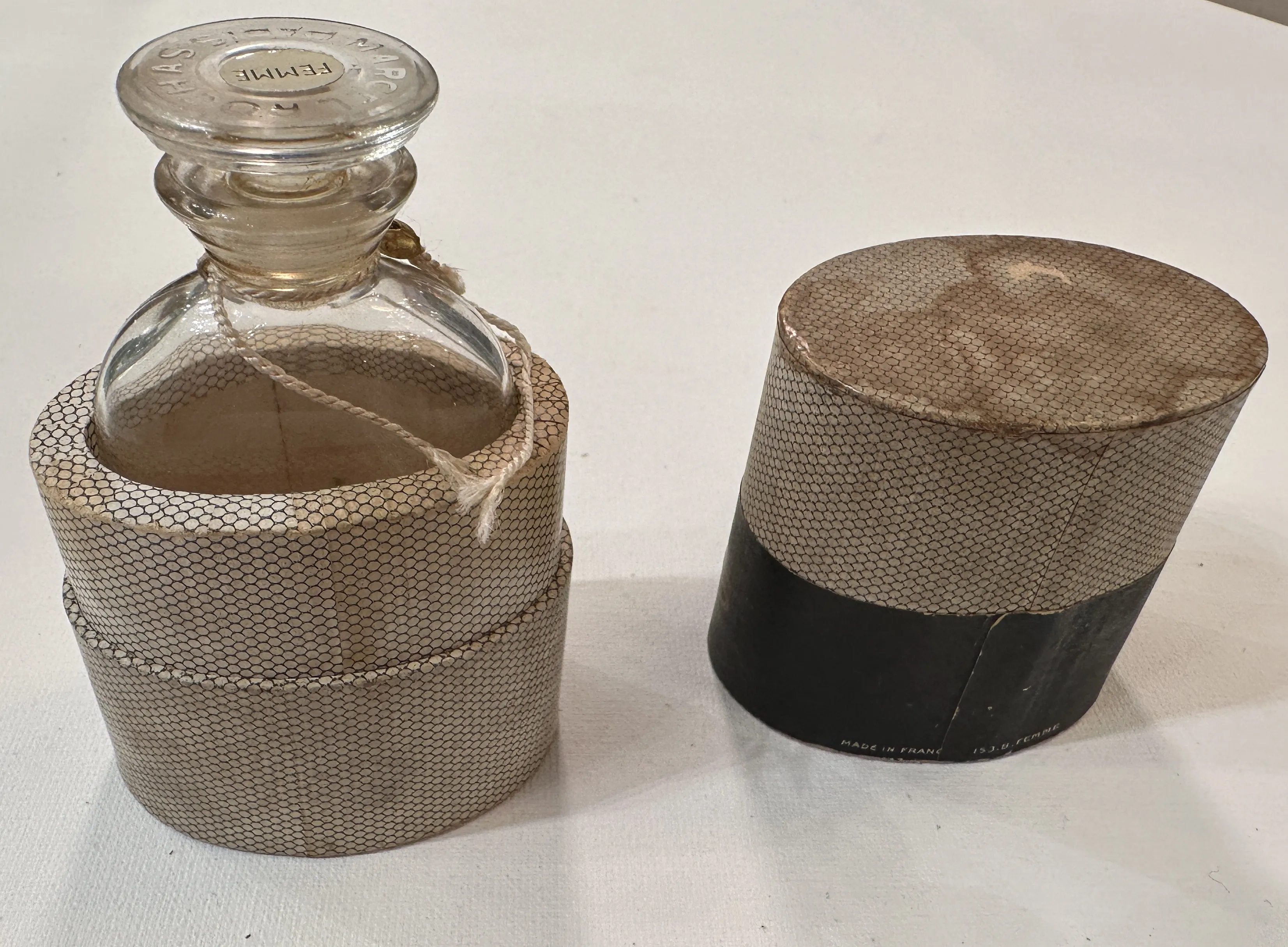 Flacon de parfum ancien avec un couvercle décoratif dans un environnement neutre