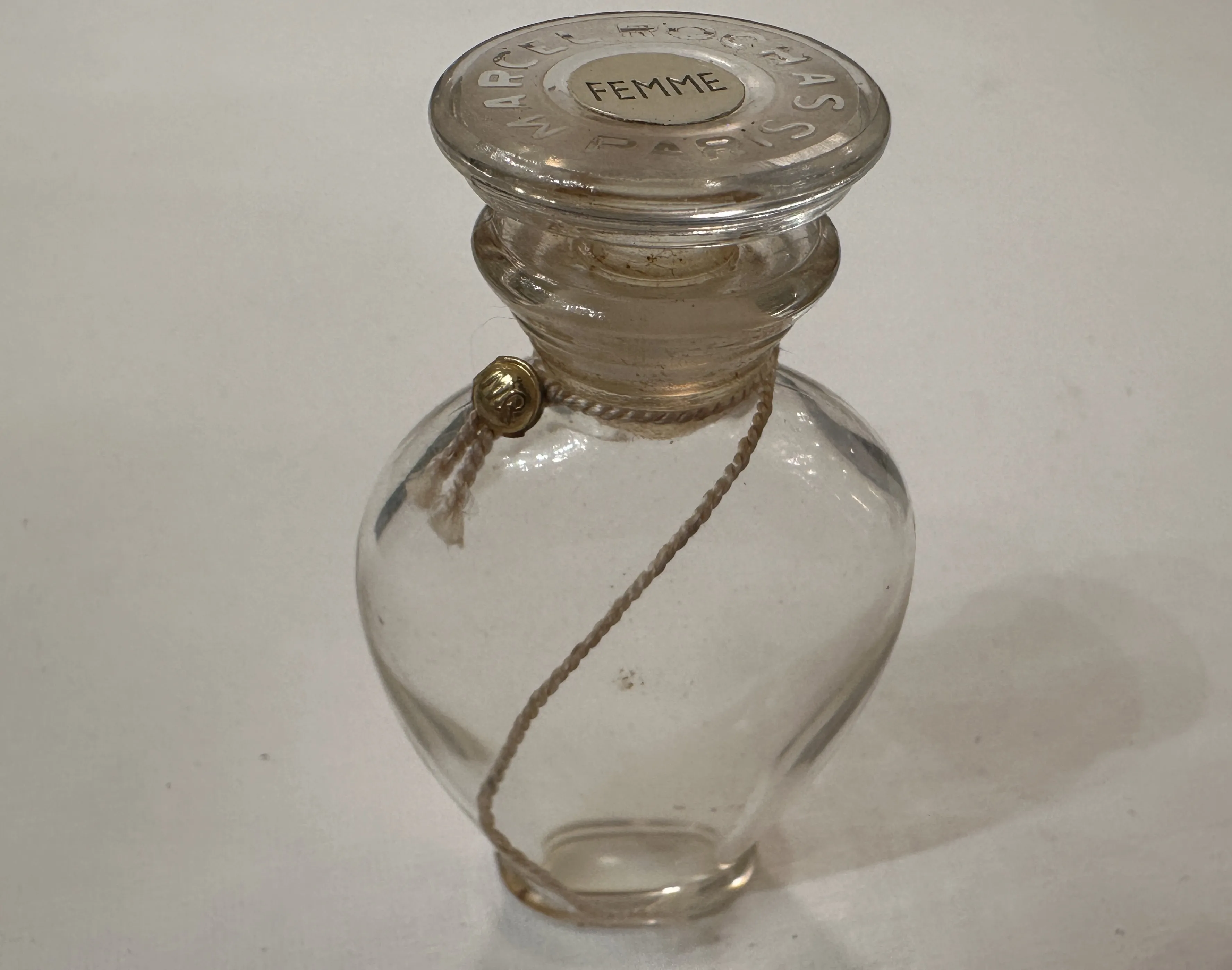 frasco de perfume antigo com tampa de vidro e cordão decorativo