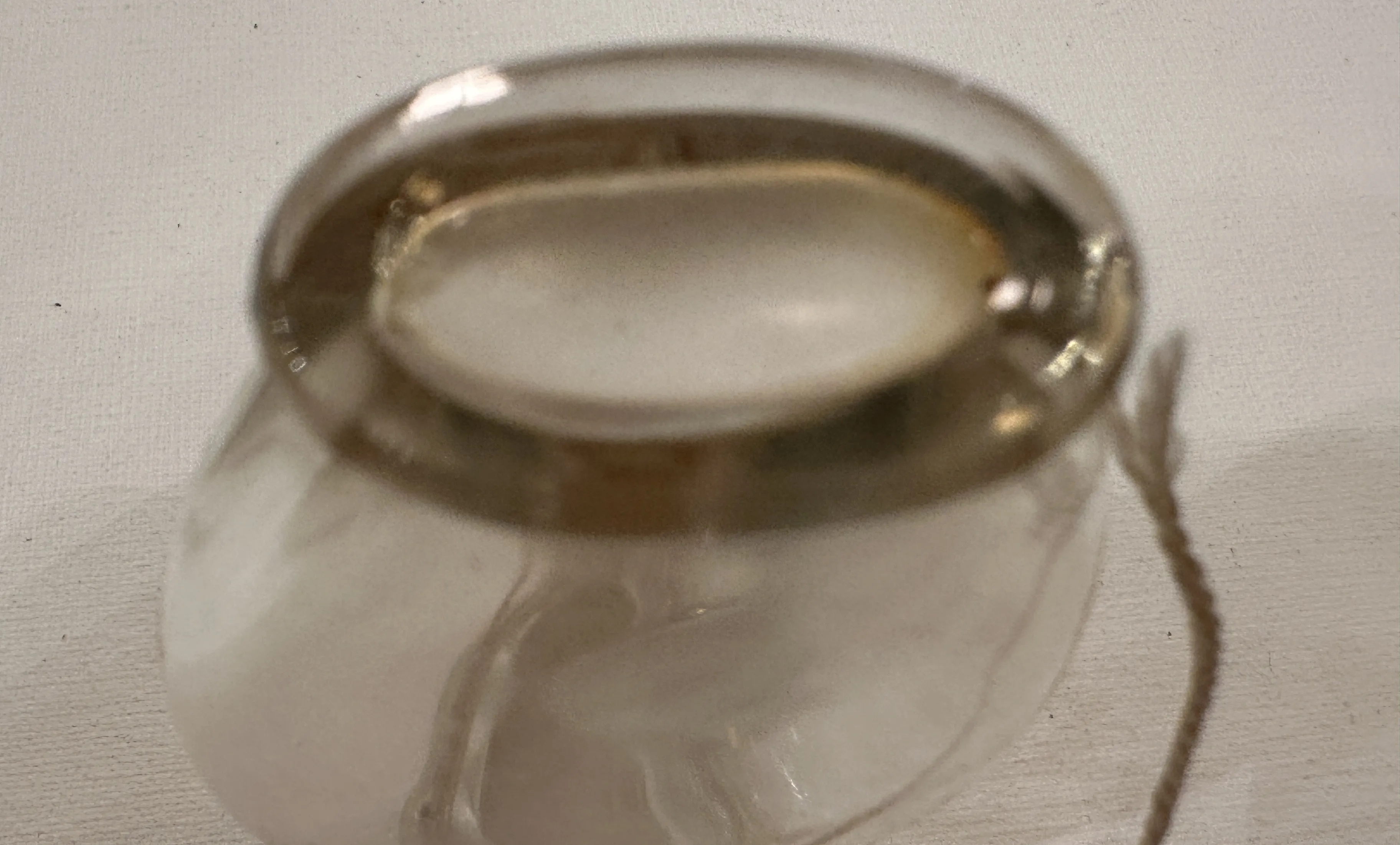 Frasco antigo de perfume com tampa oval e corda.