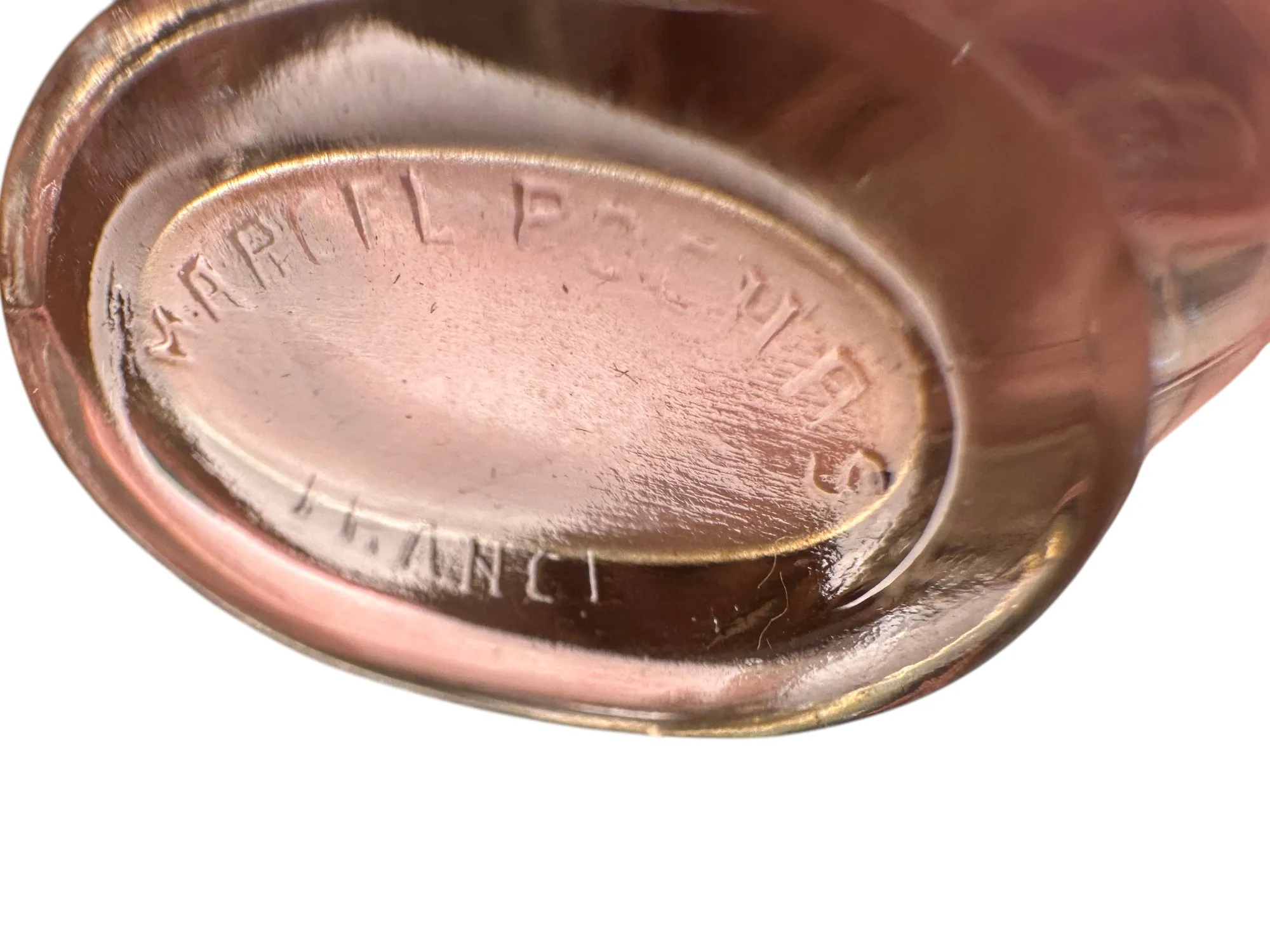 Frasco de perfume antigo com gravação detalhada, fundo suave.