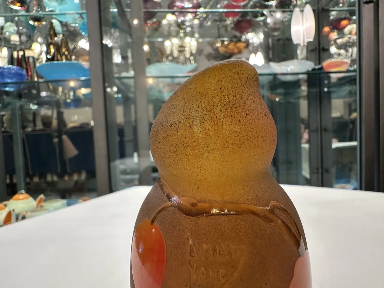 Verre signé Daum Nancy avec des motifs circulaires rouges.