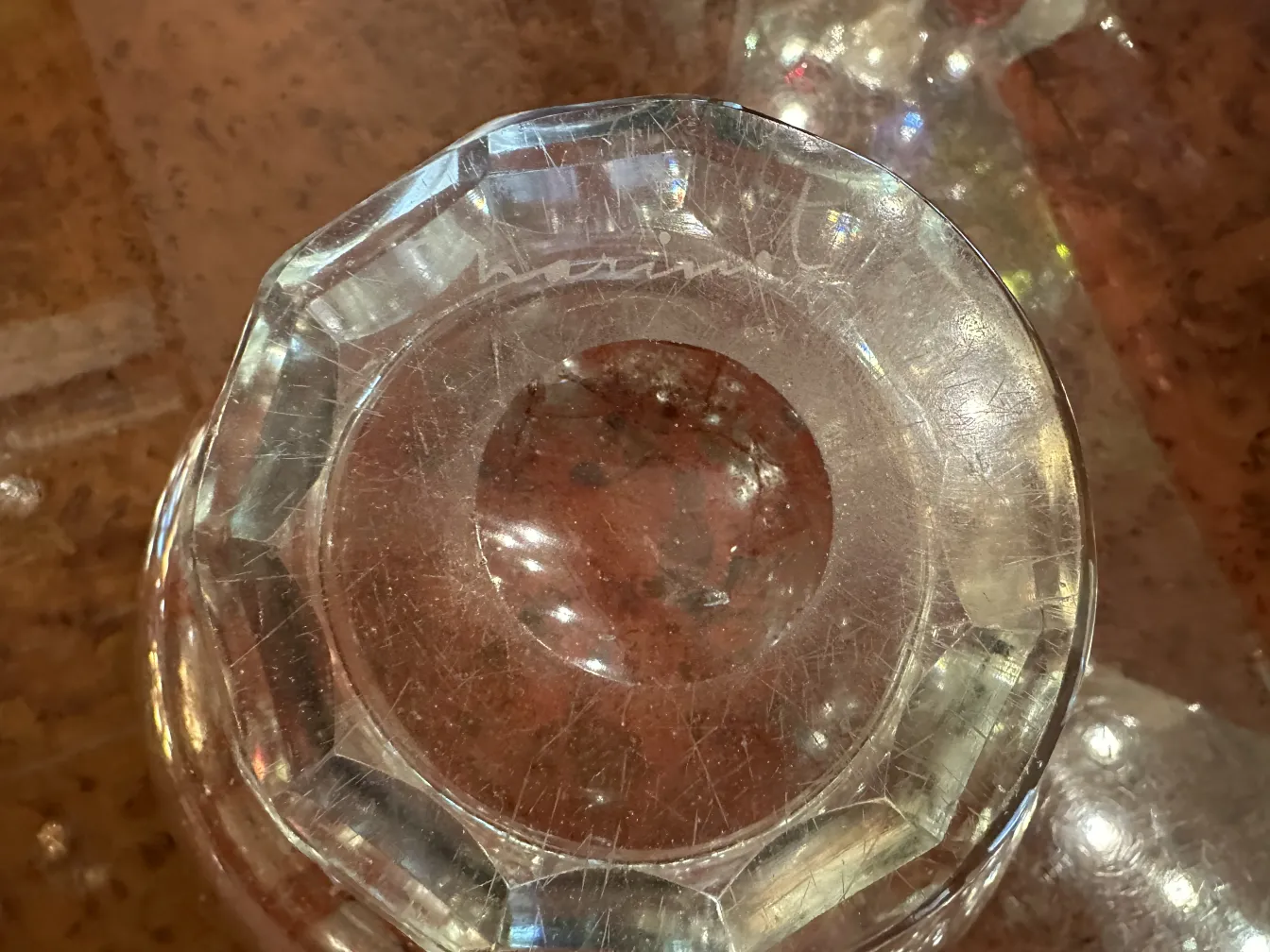Antikes signiertes Marinotglas in leuchtend roter Farbe auf klarer Basis, mit sichtbaren Details.