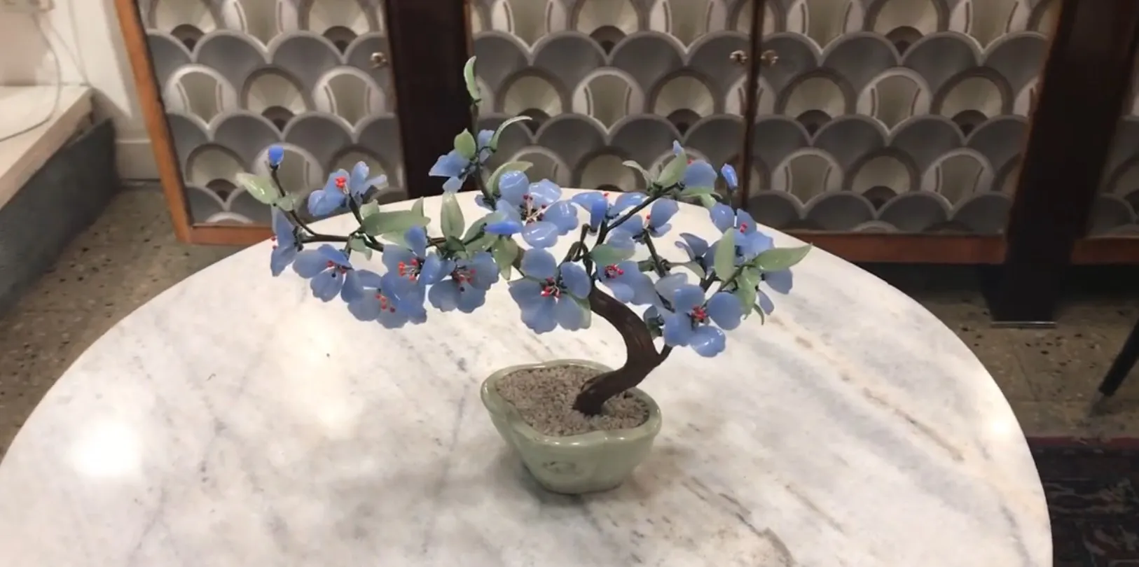 Antiker Bonsai mit blauen Blumen in einem Topf