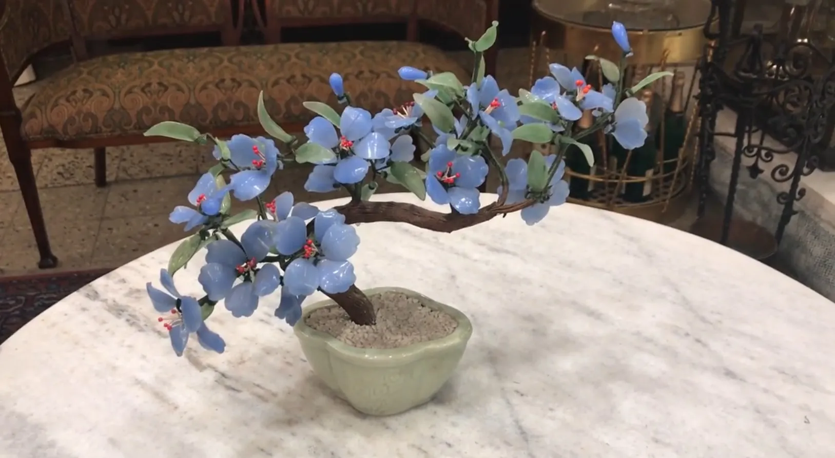 Beautiful bonsai with blue flowers in an antique setting.