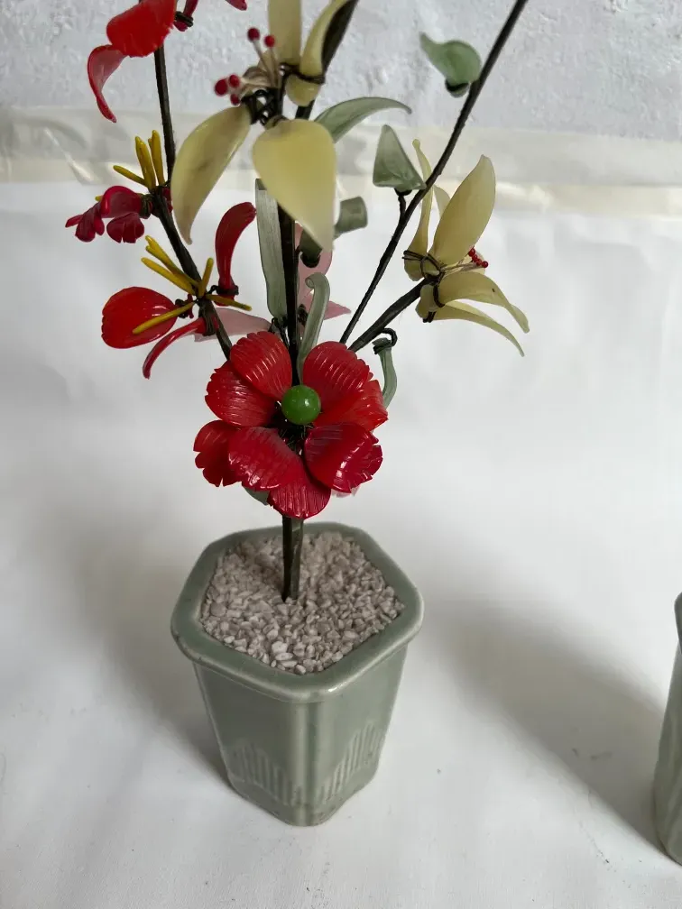 Bonsai antigo com flores vermelhas e amarelas em vaso.