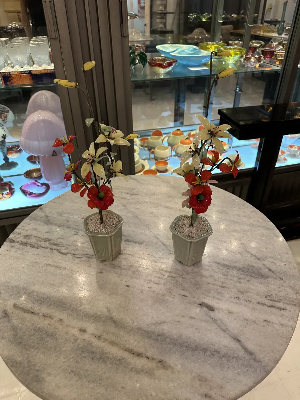 古美術の盆栽が大理石のテーブルに赤と白の花と共に