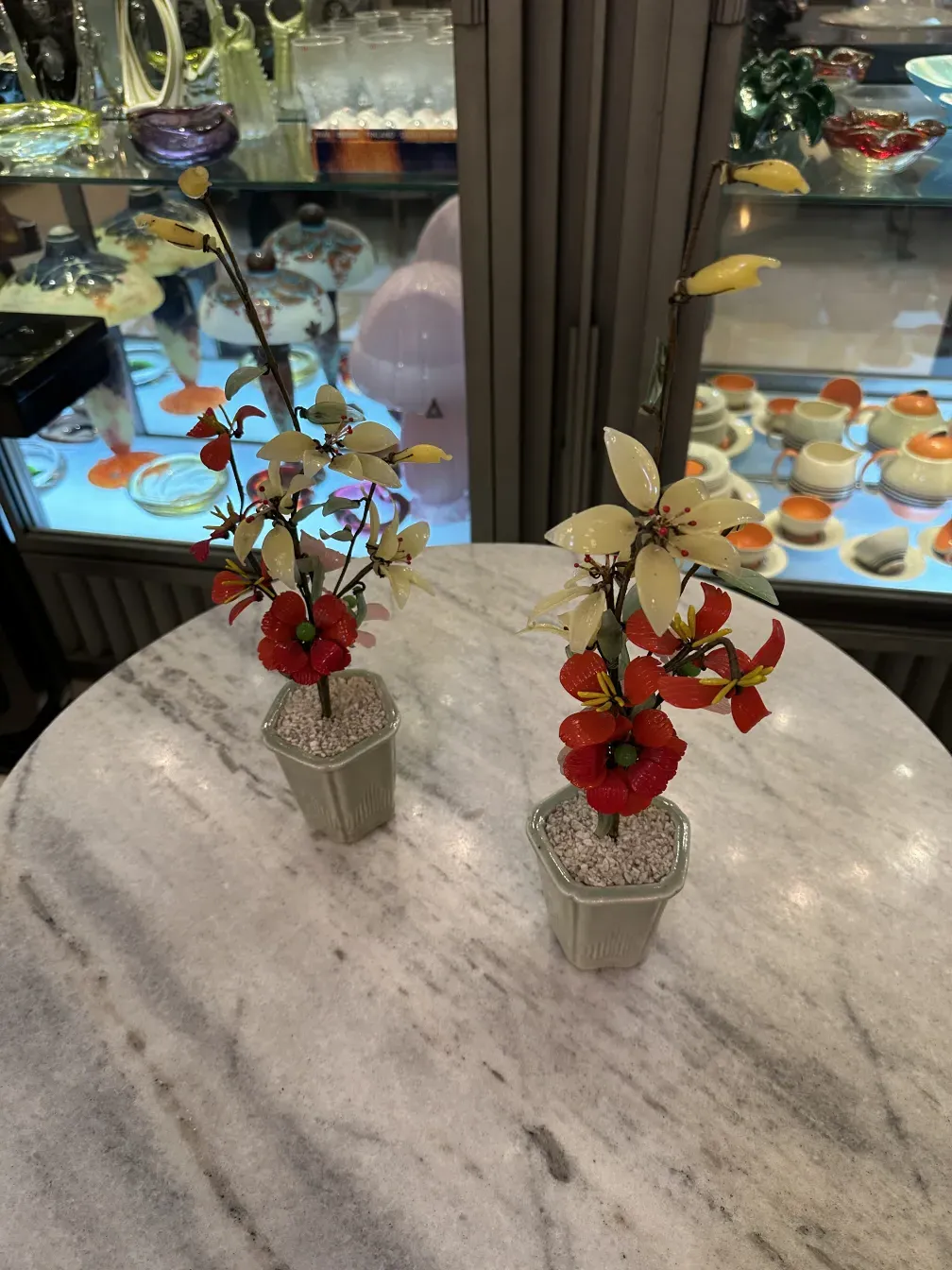 Alter Bonsai mit blühenden Zweigen in dekorativen Töpfen