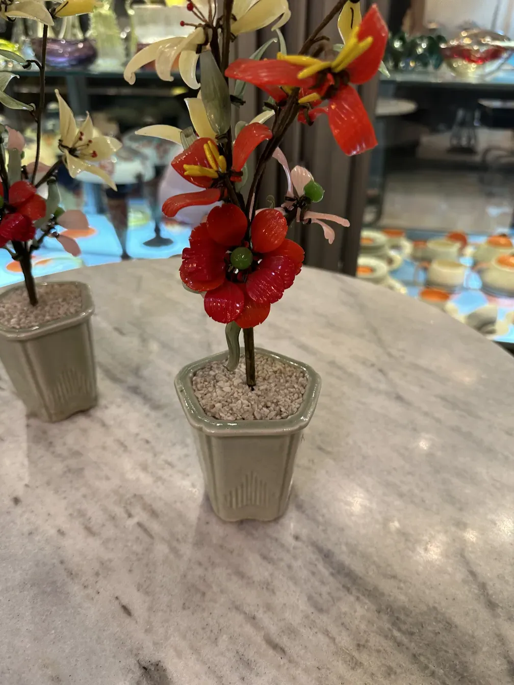 Bonsai antico con fiori rossi e gialli in vaso di ceramica.