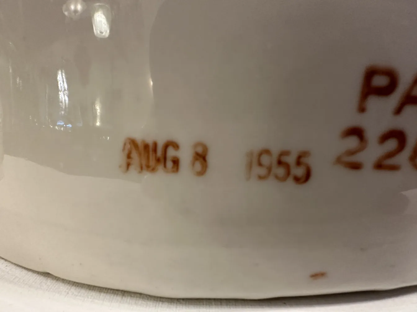 Par de mãos de cerâmica, antigas e brilhantes, mostrando detalhes da forma em um ambiente neutro.