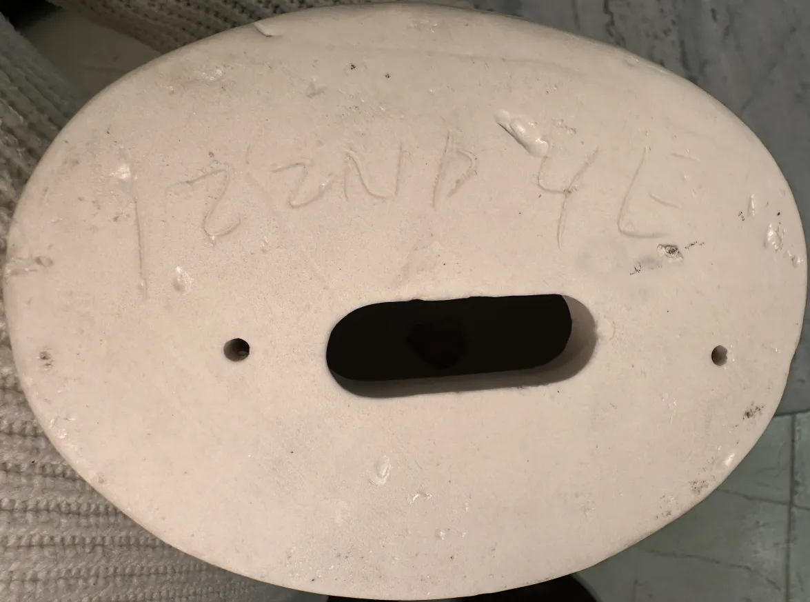 Coppia di mani in ceramica, antiche e lucide, con dettagli nella forma in uno sfondo neutro.