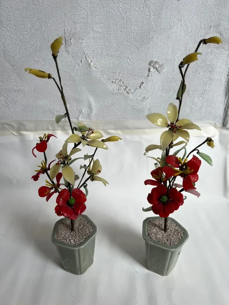 Antique bonsai in a ceramic flower pot, adorned with red and yellow flowers.