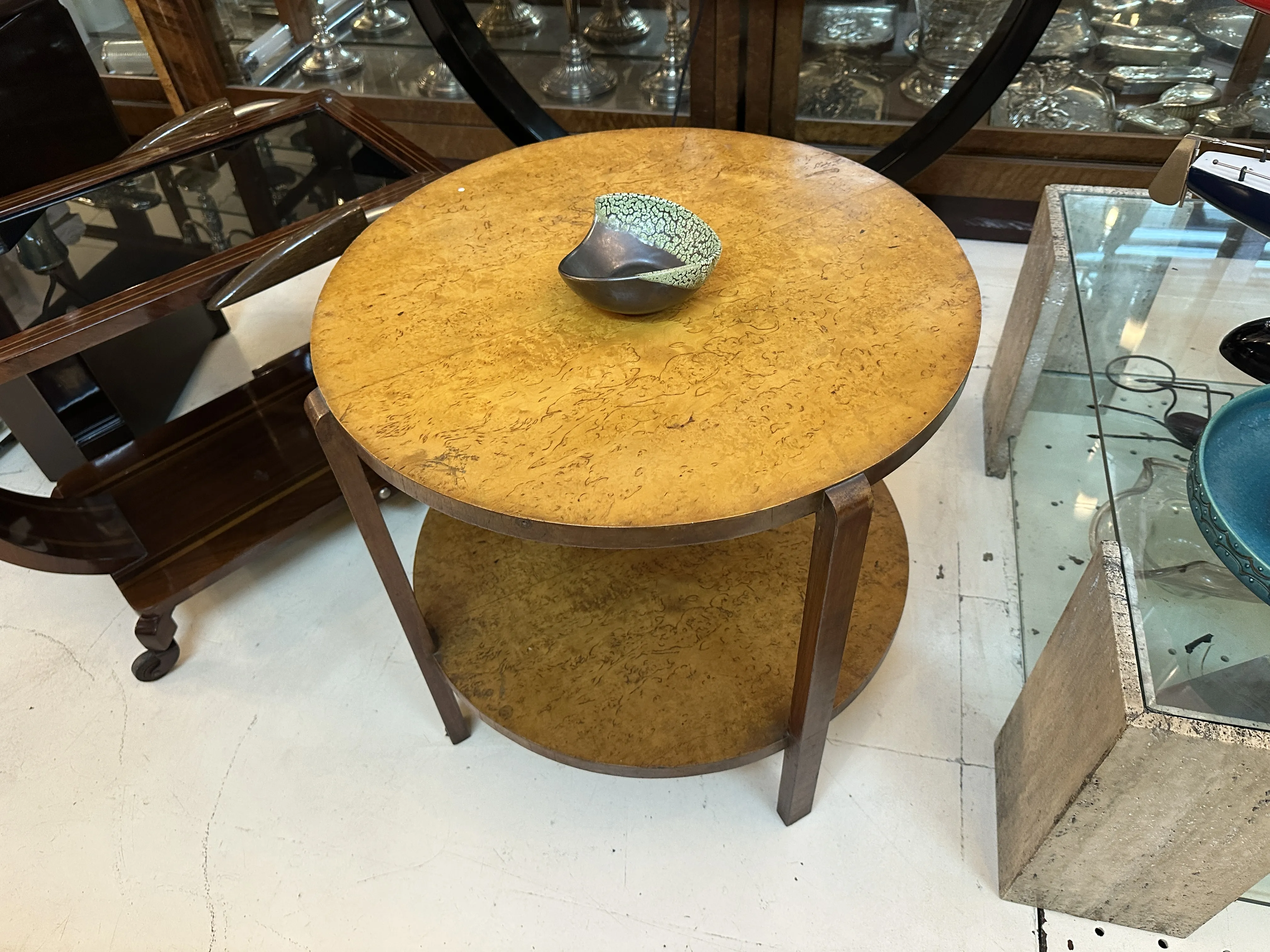 Mesa redonda de madera con una cerámica en la parte superior, en un ambiente antiguo y acogedor.