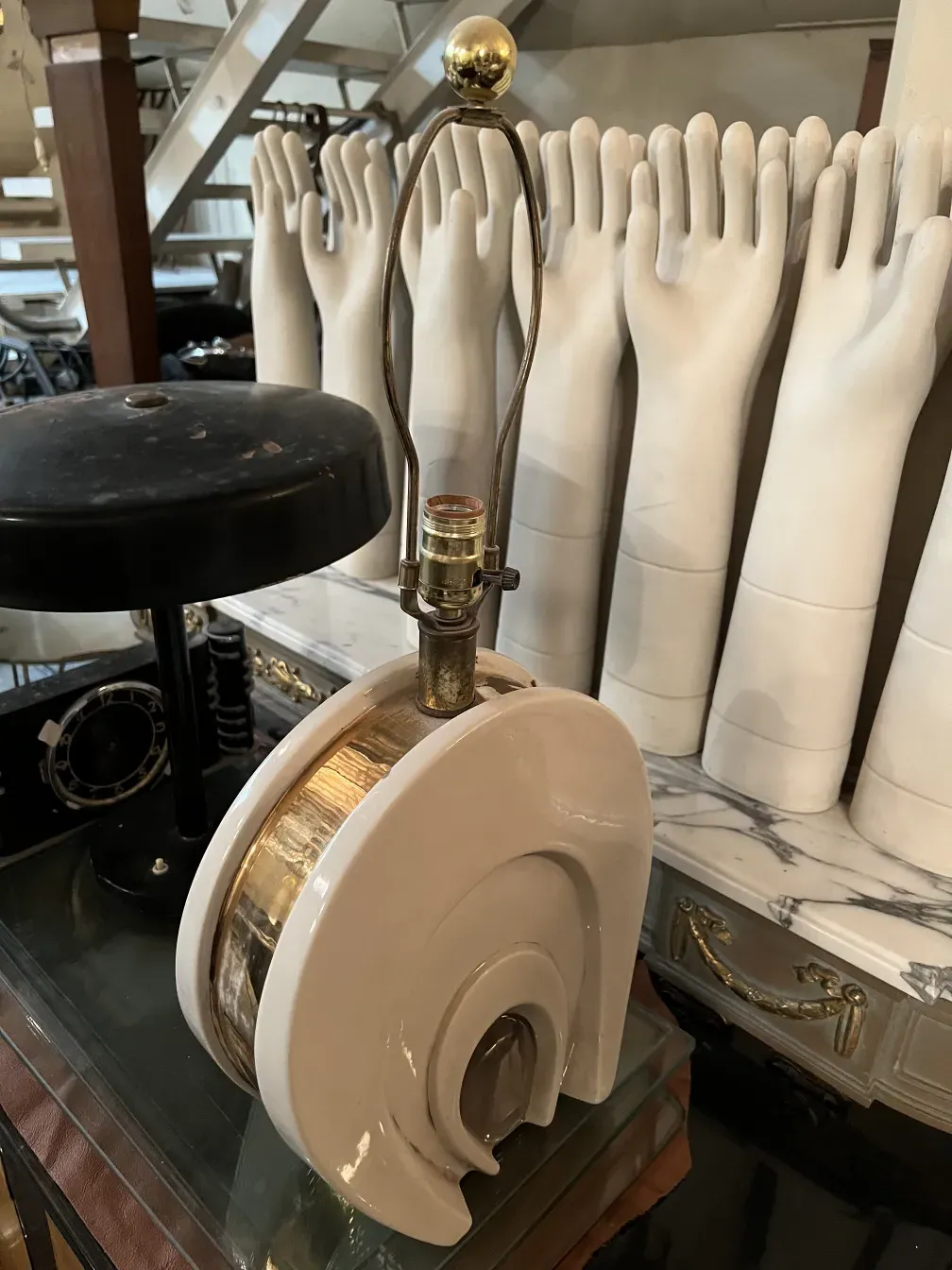 Antike Tischlampe im Art Deco-Stil mit runder Basis und goldenen Details, in einem vintage Ambiente.