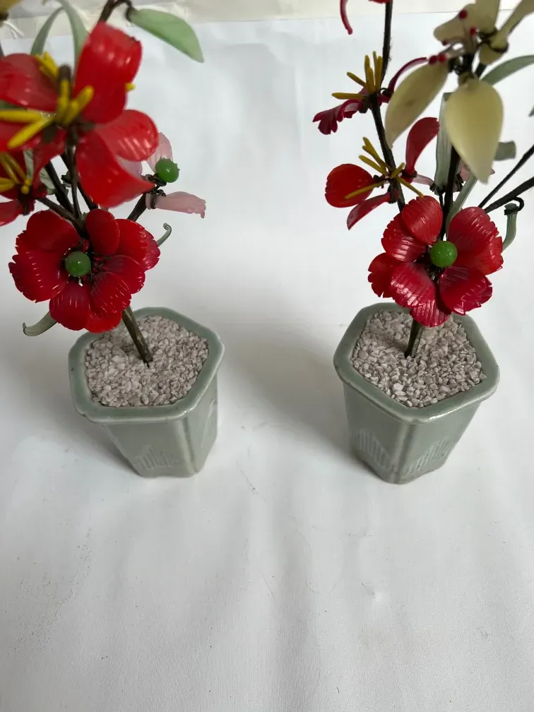 Bonsai antico con fiori rossi e verdi in vasi