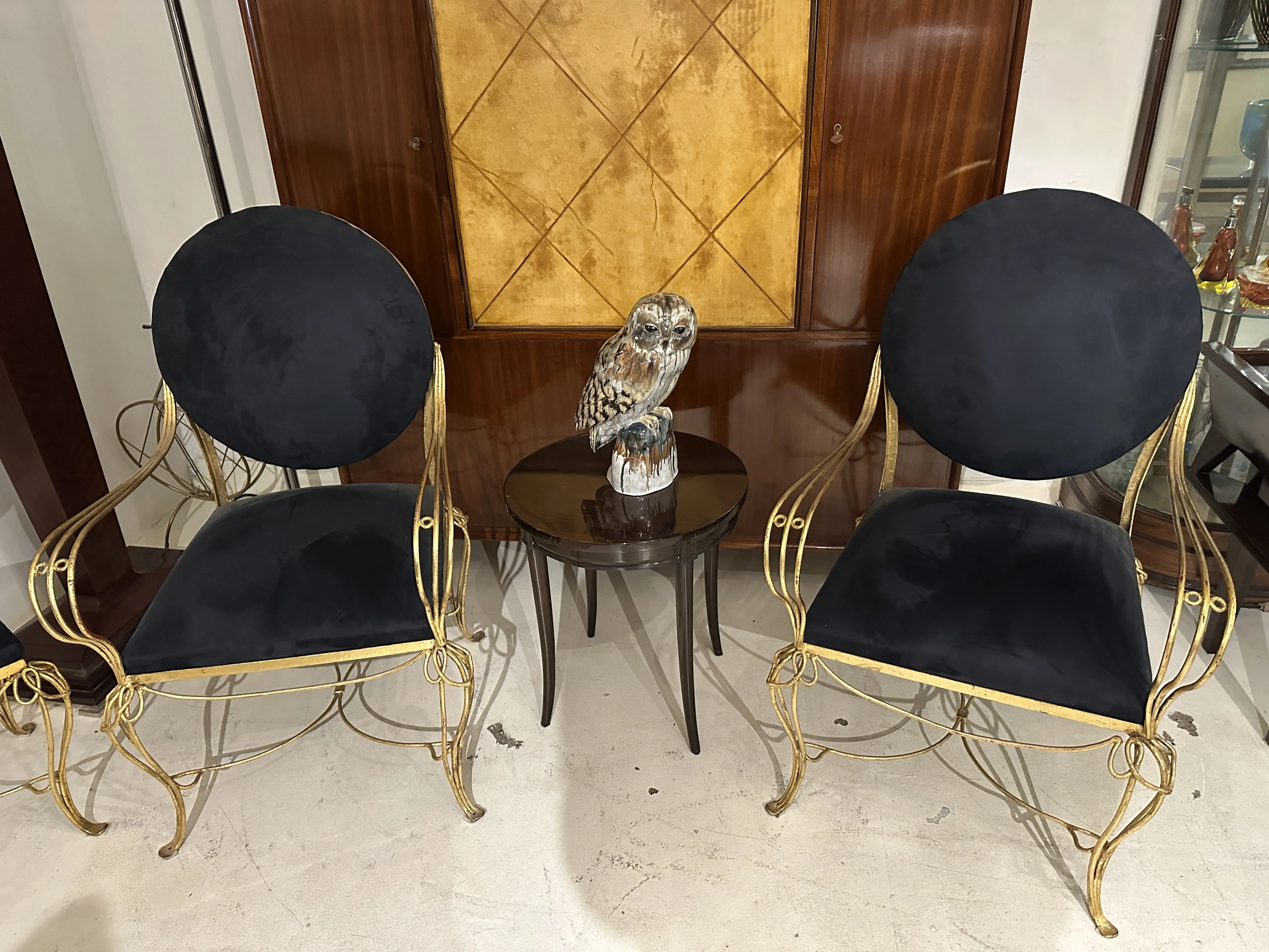 Deux chaises anciennes à côté d'une chouette en céramique décorative.