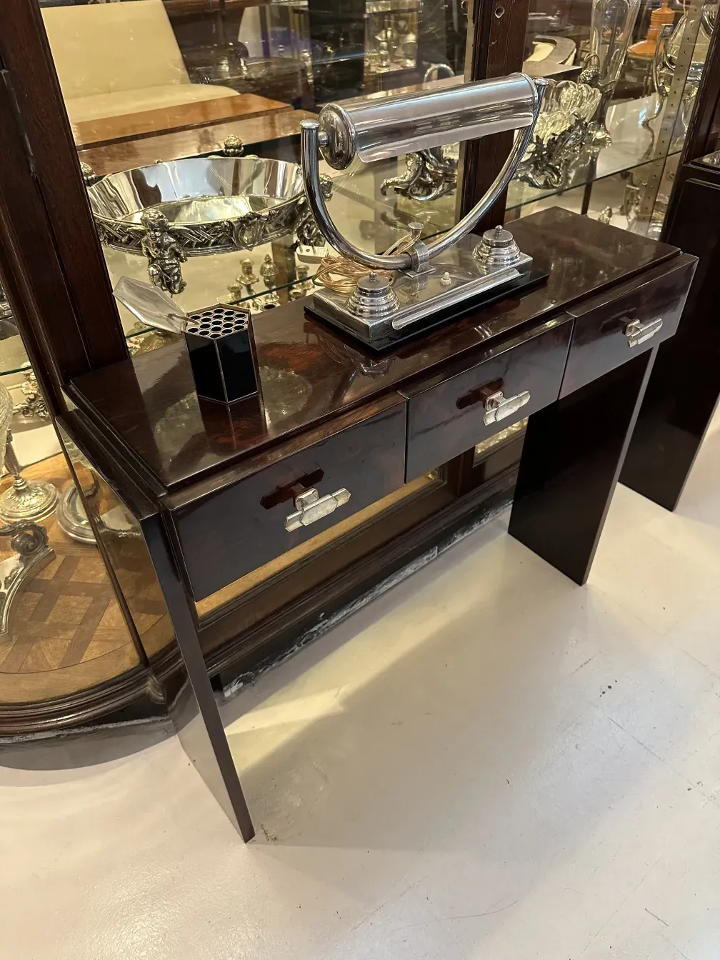 caja antigua con detalles y compartimentos visibles, rodeada de antigüedades