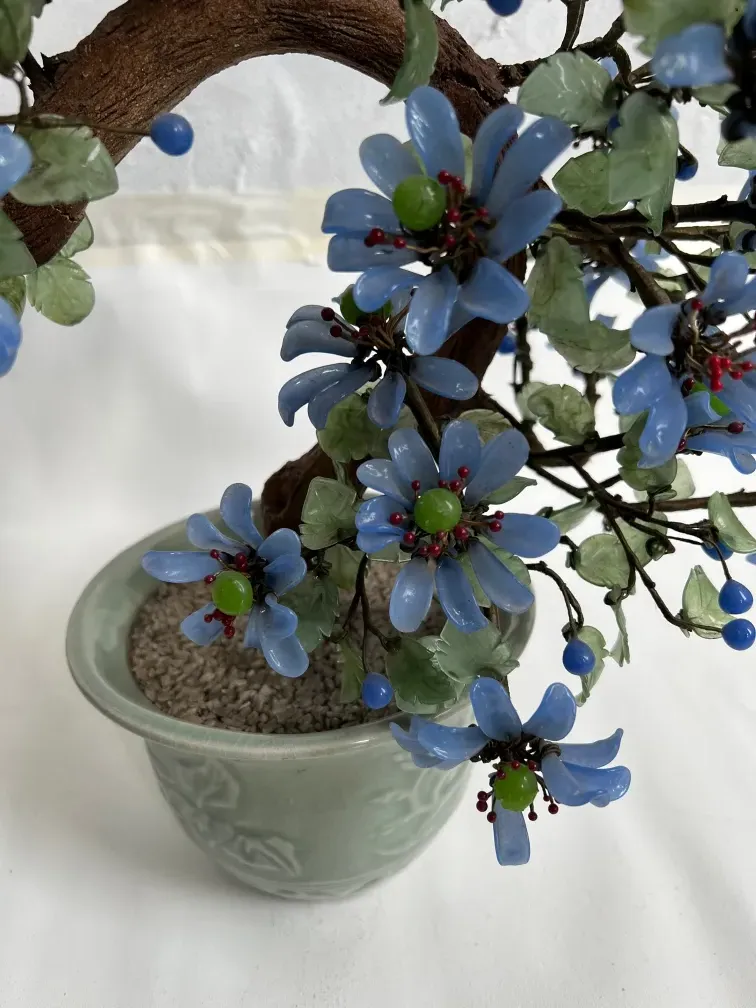 bonsai antico con fiori blu e foglie verdi decorative