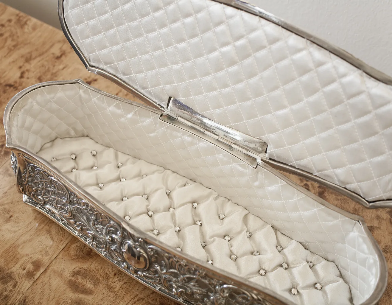 Caja antigua decorada con diseño elegante y interior acolchado.
