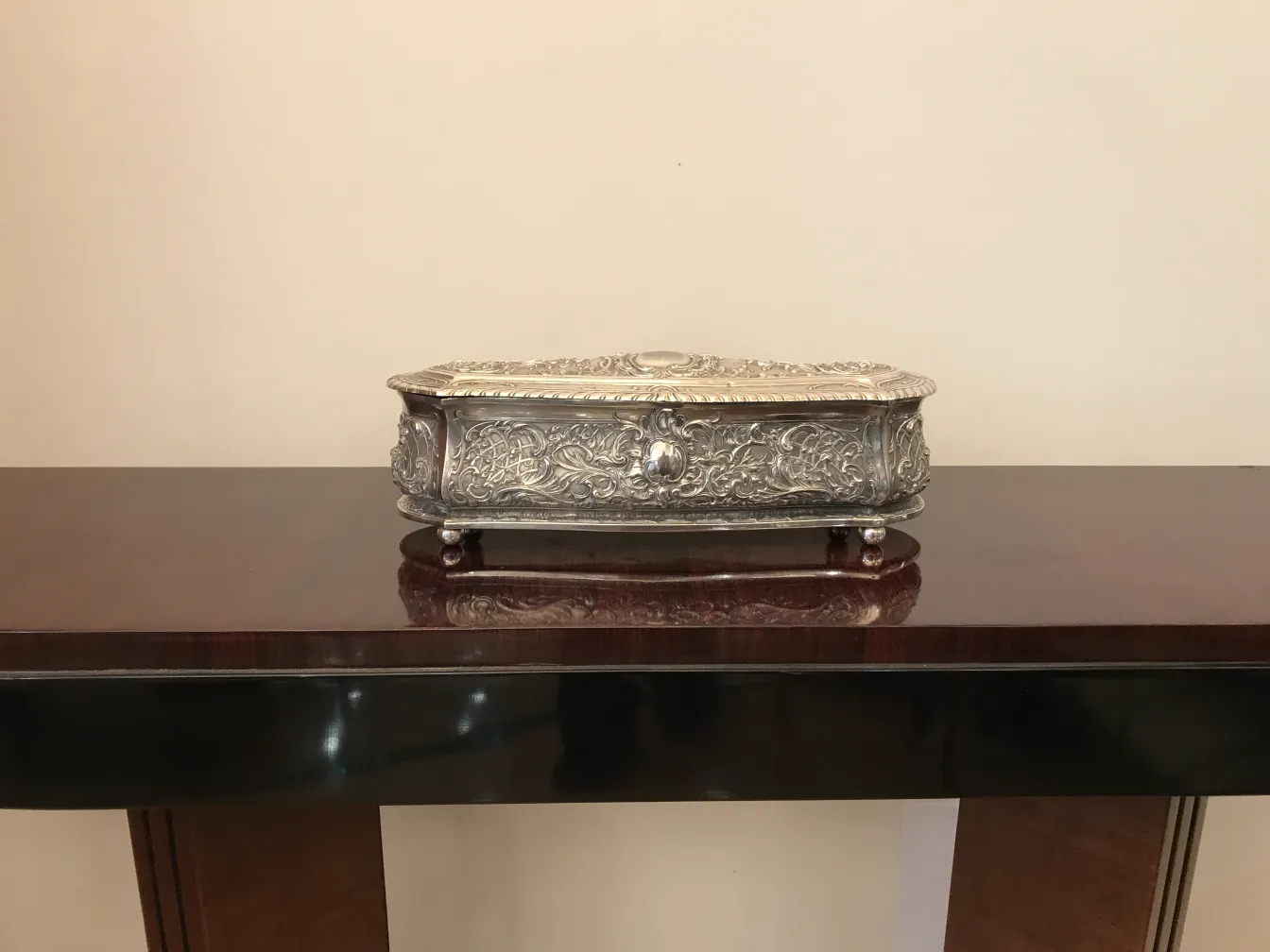 Caixa antiga decorativa com detalhes intrincados sobre uma mesa.