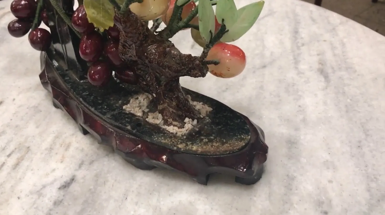 Antiker Bonsai mit dekorativen Früchten in eleganter Basis.