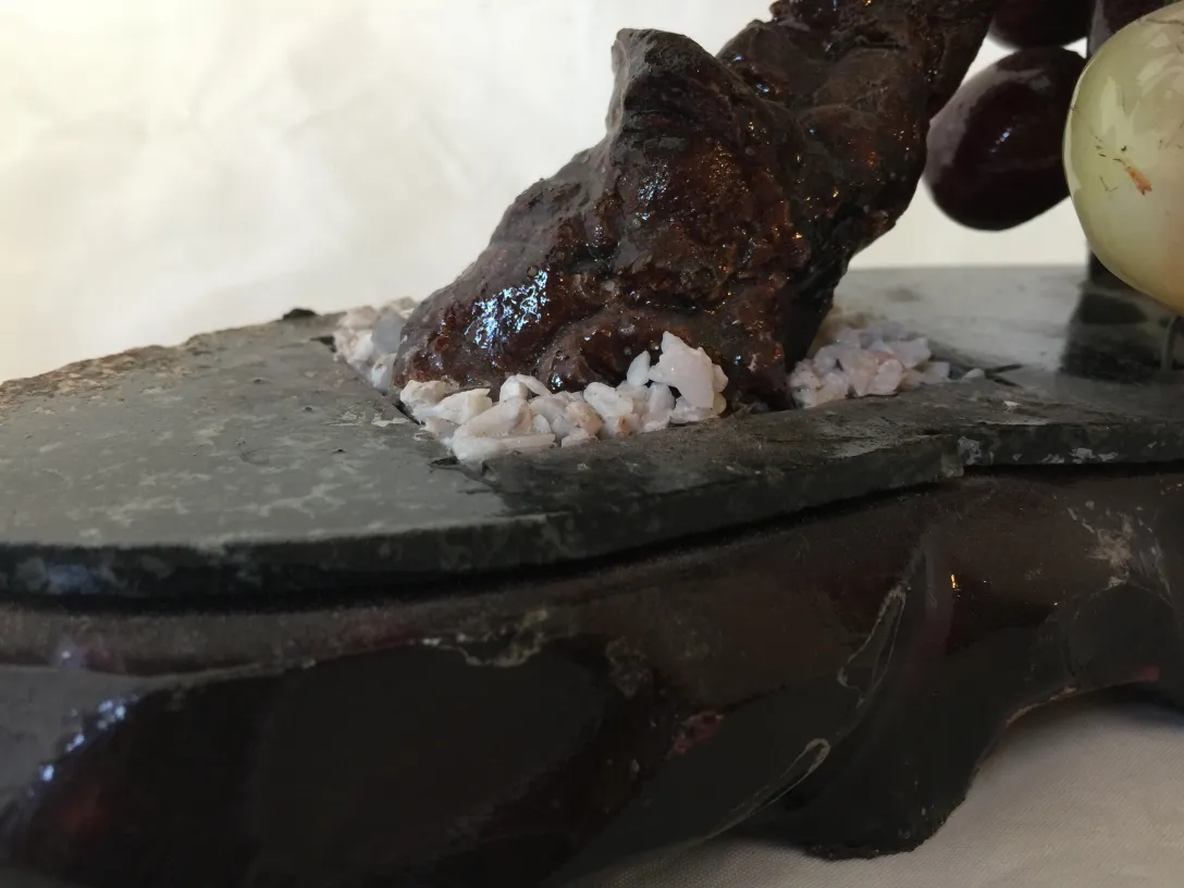 Bonsai sur base noire avec pierres blanches et fond neutre