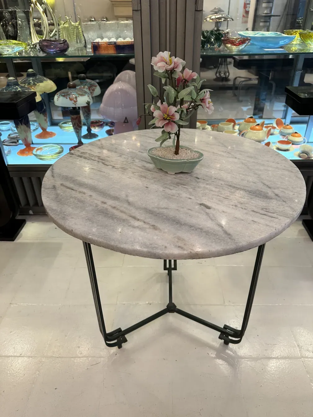 Bonsái antiguo en maceta con flores delicadas en mesa de mármol