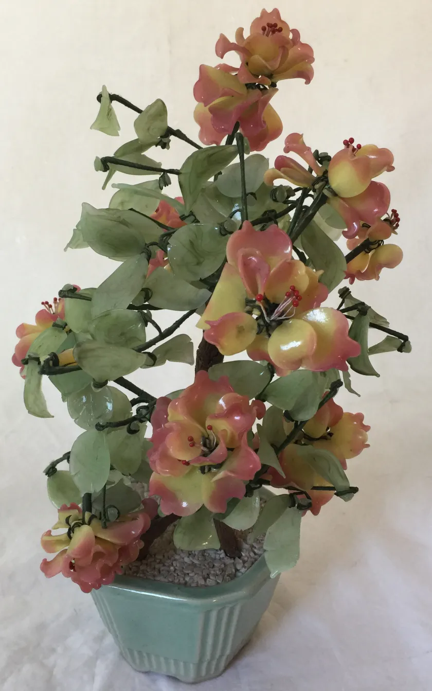 Bonsai avec des fleurs roses et jaunes dans un pot vert, ancien.