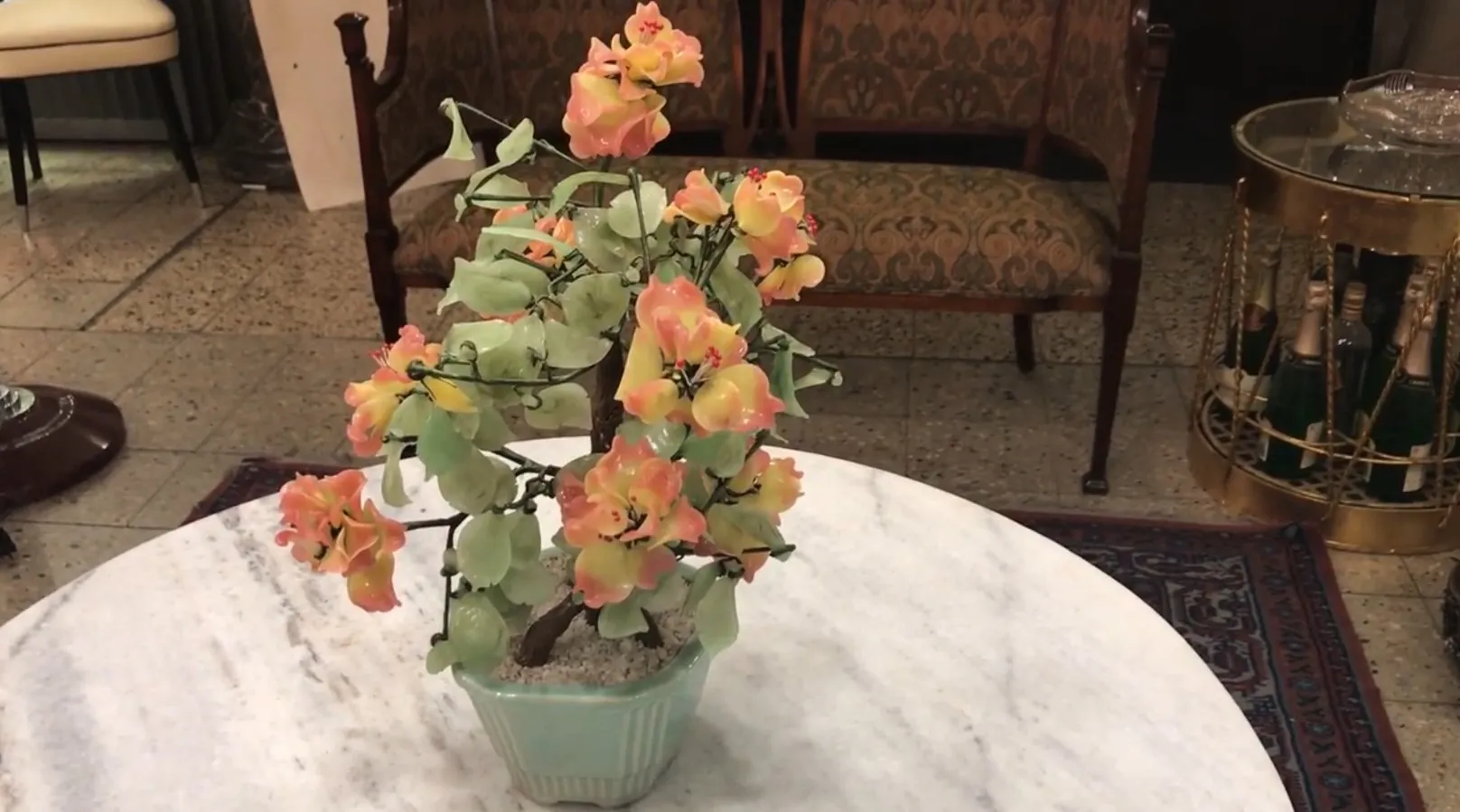 Bonsai antigo com flores em tons de rosa e amarelo.