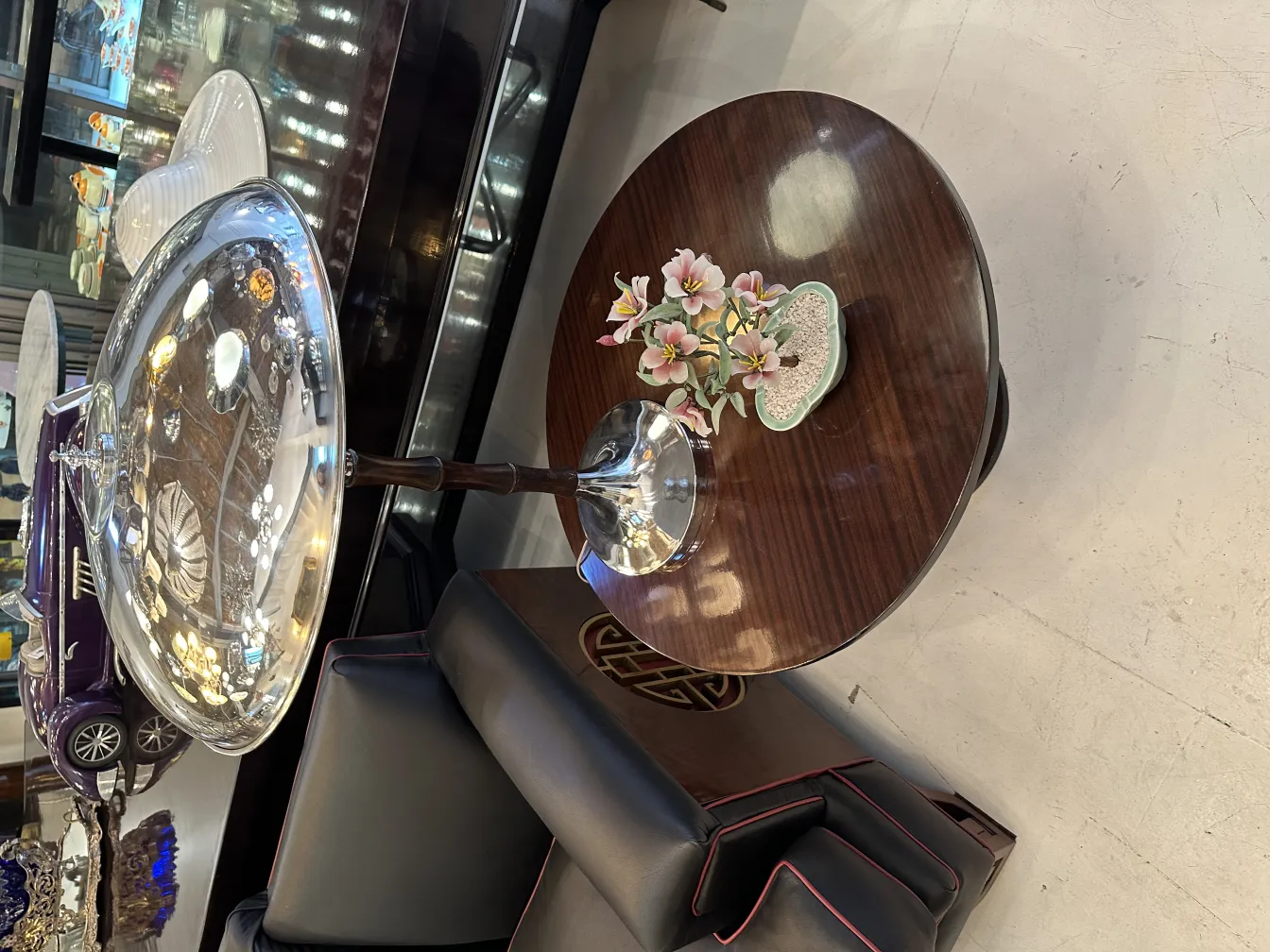 Bonsái antiguo con flores en una mesa elegante.