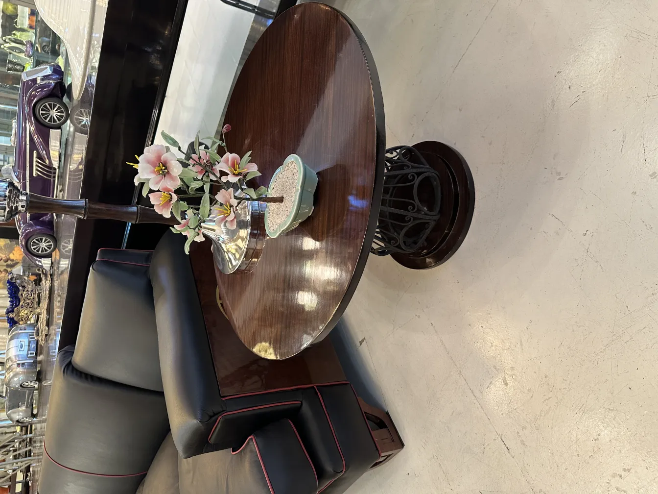 Bonsai antigo em vaso de cerâmica com flores decorativas e ambiente elegante.