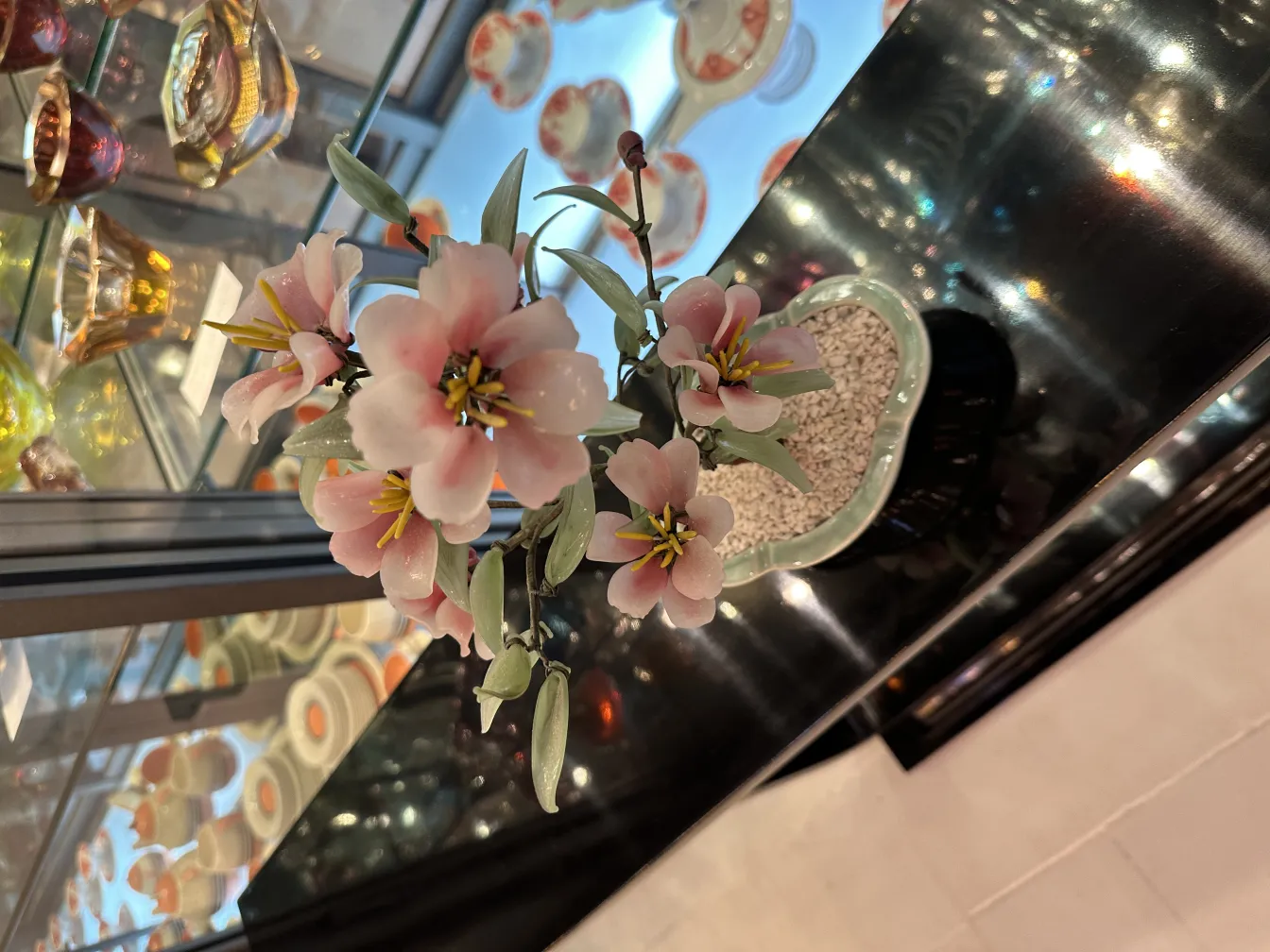 Bonsai antico con fiori rosa e verdi, decorativo.