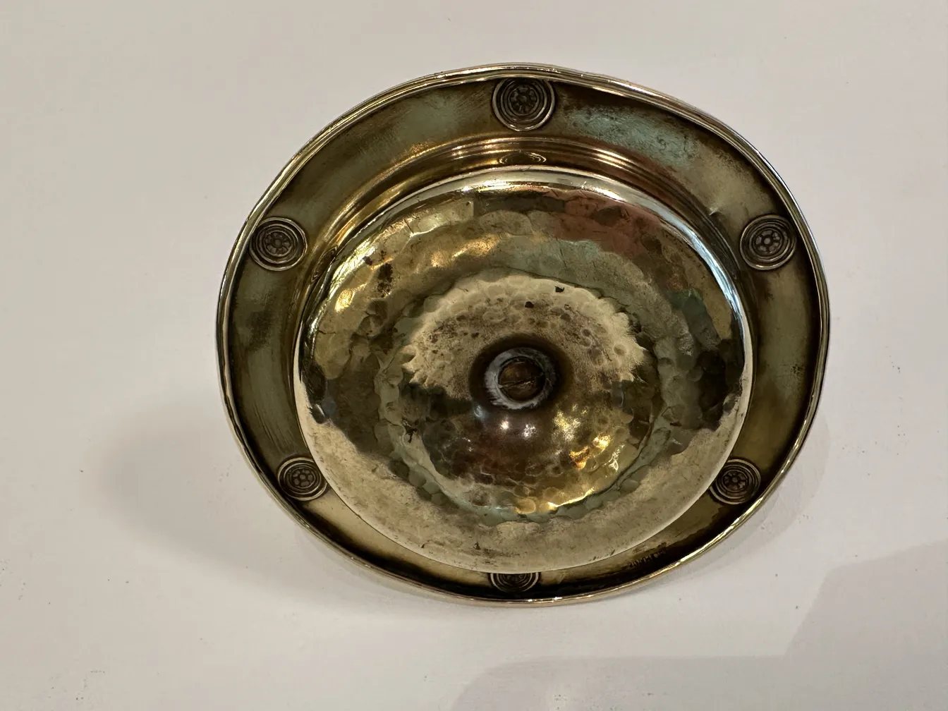 Antique WMF ashtray with decorative design and circular shape.