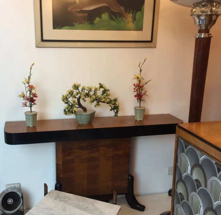 Antique decorative bonsai in a ceramic vase on a table with flowers