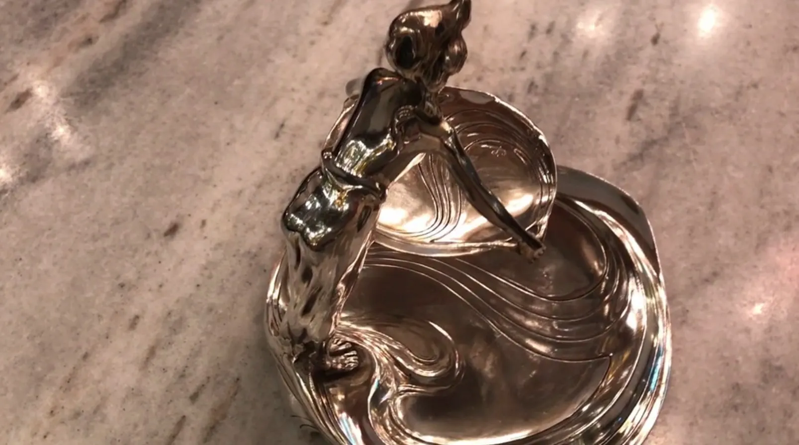 bandeja antiga com uma figura de mulher em movimento
