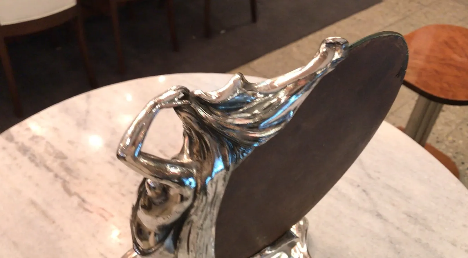 antique decorative mirror featuring a supporting figure