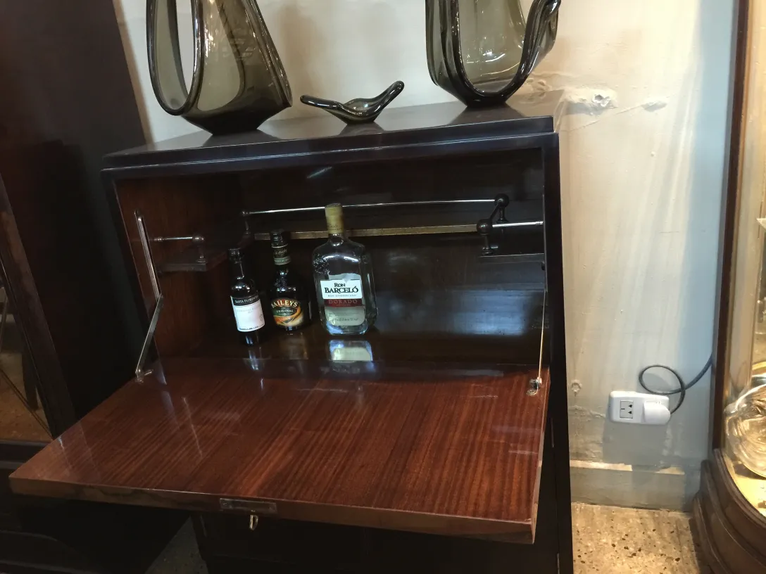 Mueble bar antiguo de madera con botellas, elegancia en cada detalle.