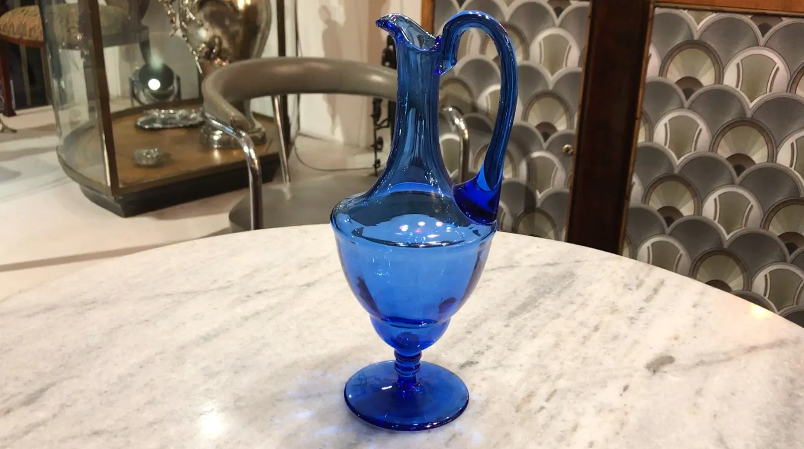 Ancien pichet bleu décoratif sur une table avec fond
