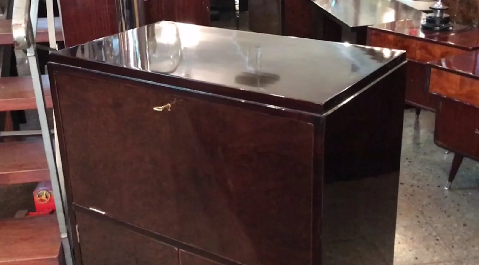 Mueble bar antiguo con un acabado brillante, entorno elegante.