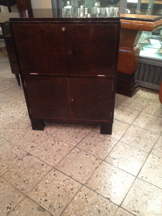 Mueble bar antiguo con puertas de madera oscura en ambiente elegante.