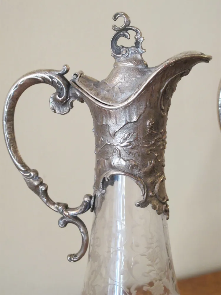 two antique WMF jars with intricate design and decorative handles, in an elegant setting