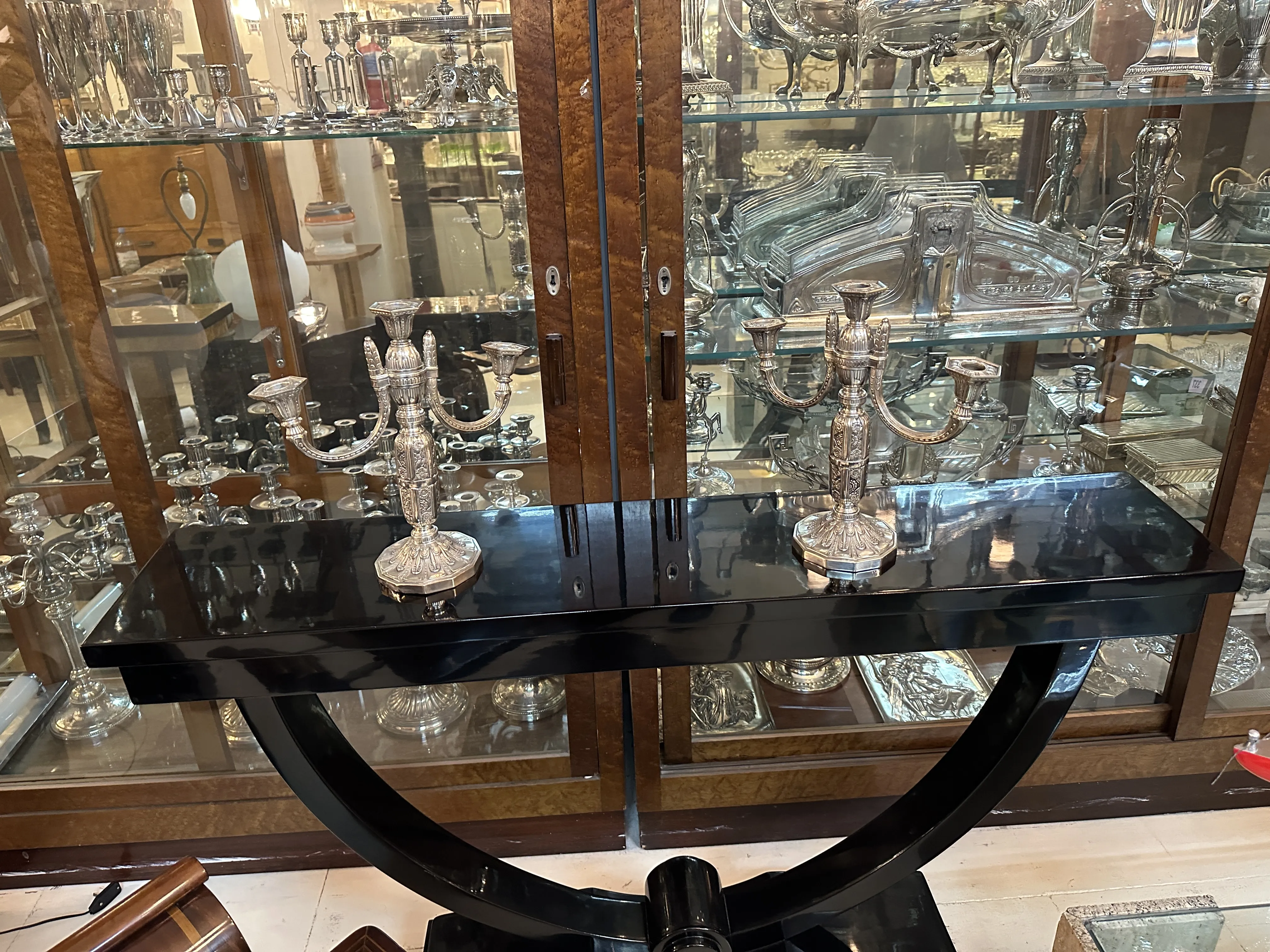 Dos candelabros antiguos sobre mesa negra, elegantes detalles.