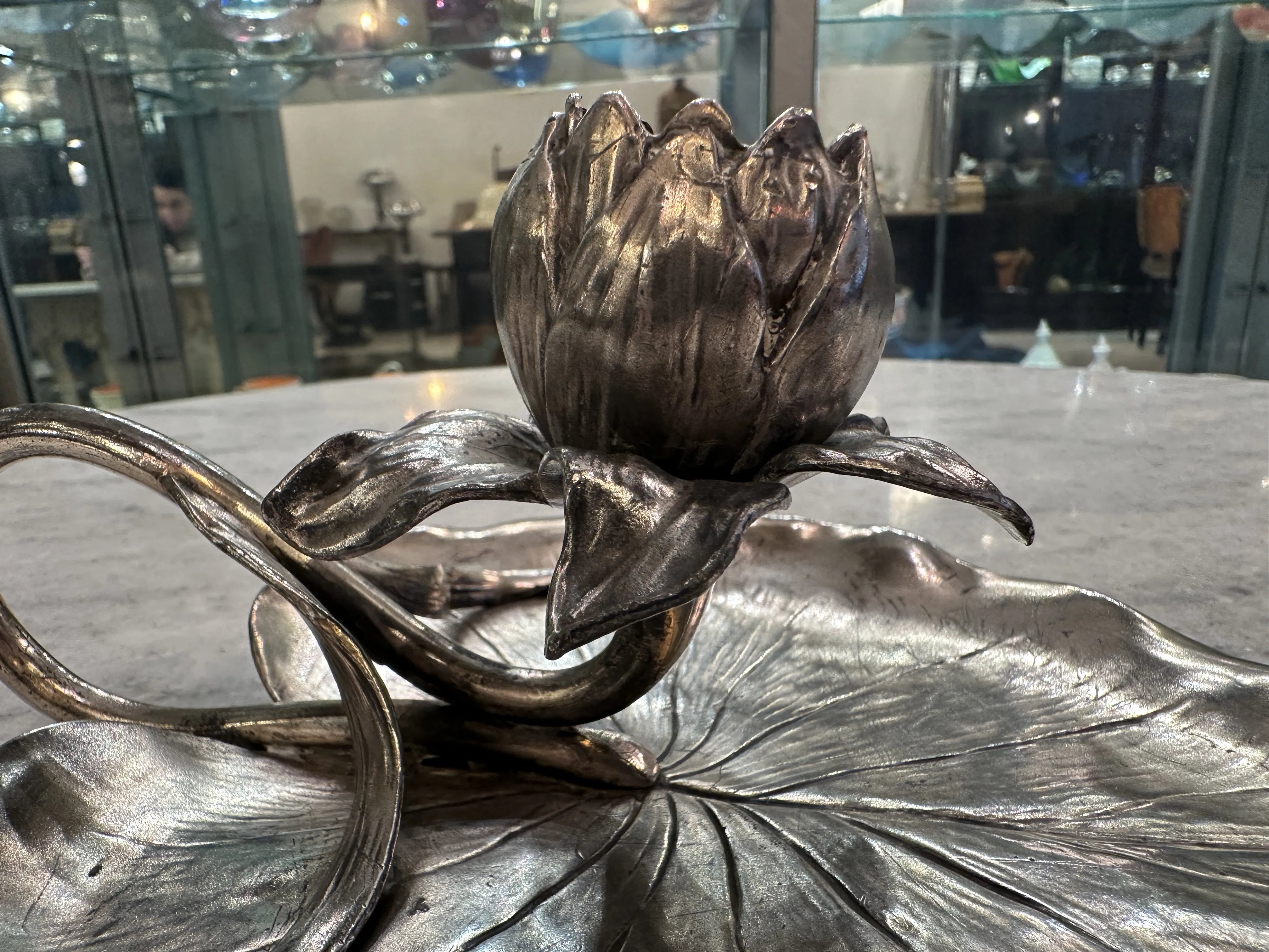Candelabro antico con fiori e foglie dettagliate.