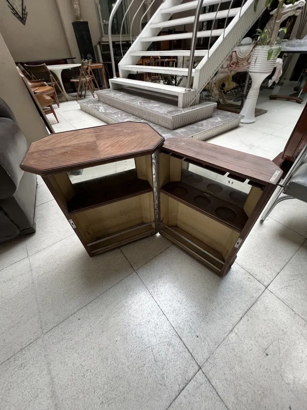 Mueble bar antiguo abierto con estantes, ambiente acogedor.