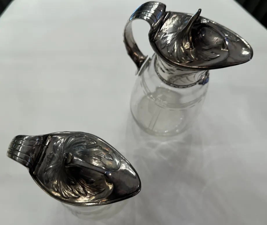 Due brocche antiche WMF con dettagli decorativi e un design elegante in un ambiente classico.