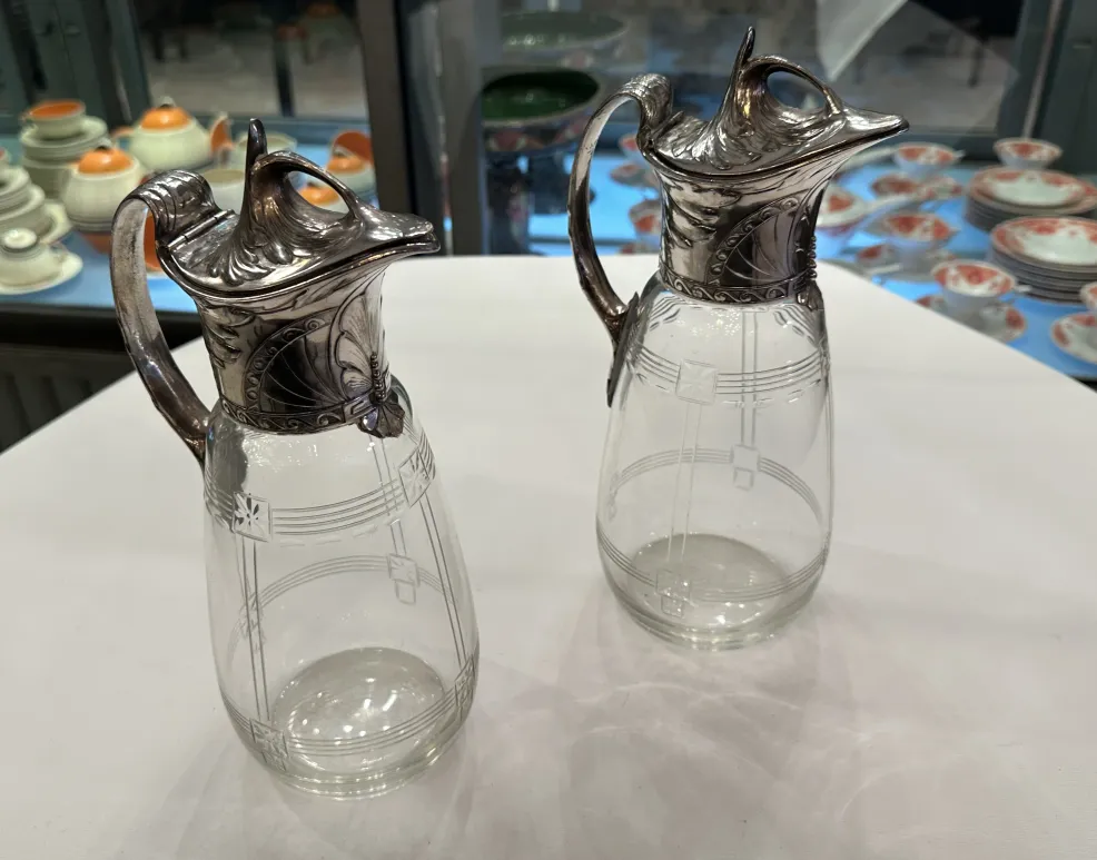 Due brocche antiche WMF con dettagli decorativi e un design elegante in un ambiente classico.
