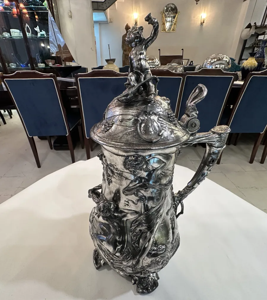 chocolatera antigua con figuras y detalles decorativos